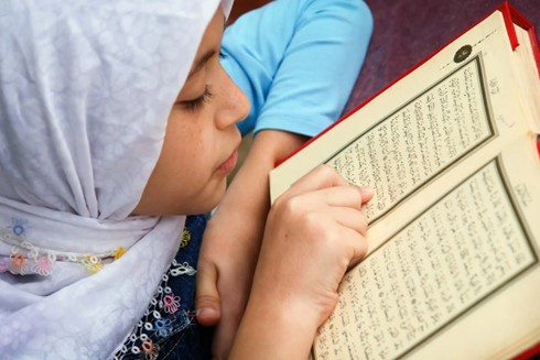 Girl reading book in arabic